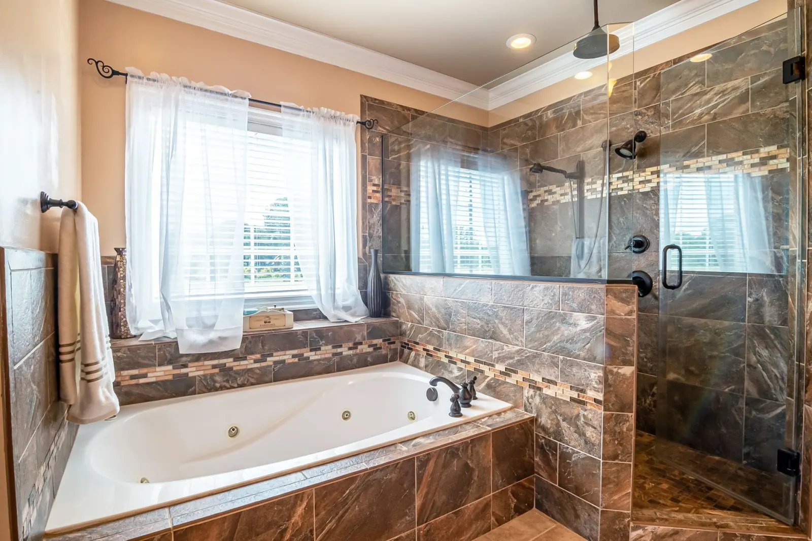 Elegant bathroom with a large bathtub and walk-in shower finished in marble tile