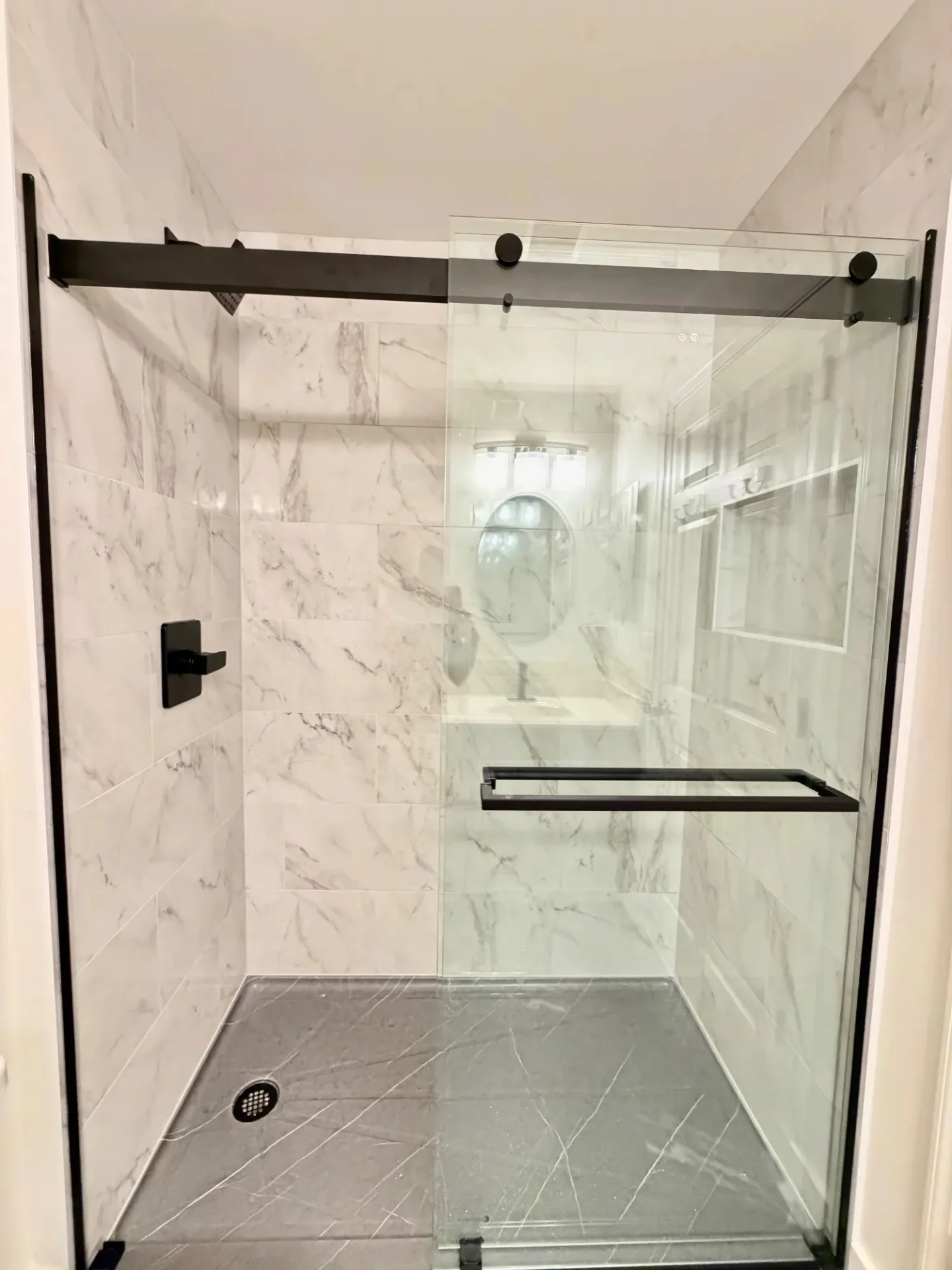 Modern bathroom with a glass shower, stone walls, and a white vanity