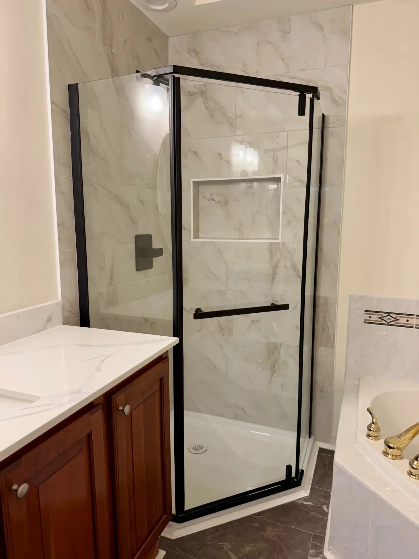 Modern bathroom with a glass shower, stone walls, and a white vanity